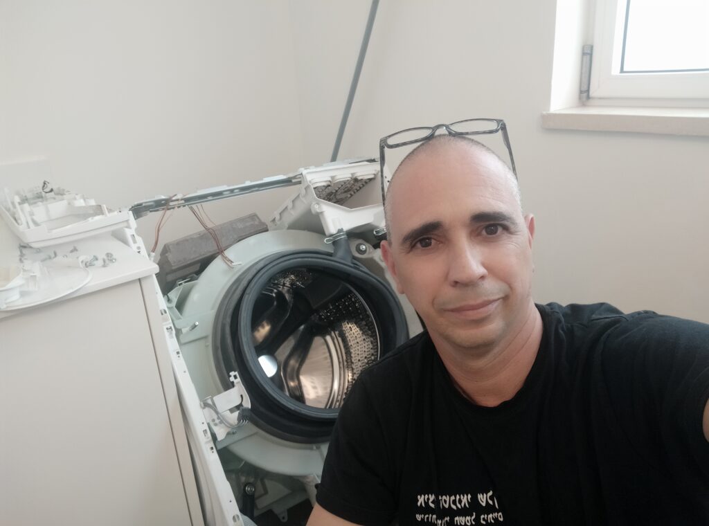 טכנאי מכונות כביסה במודיעין.מבצע תיקון בשטח על מכונת כביסה פתוחה